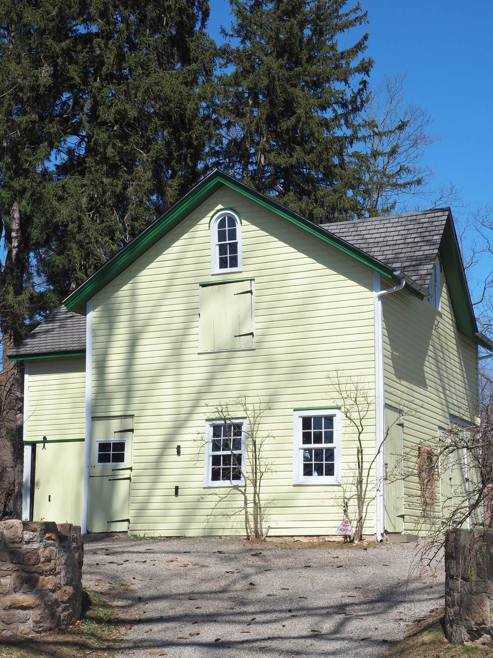 Yellow farmhouse in the Doylestown, PA countryside under a blue sky